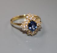 A modern 18ct gold, sapphire and diamonds set quatrefoil shaped cluster ring, size M, gross 4