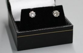 A pair of white metal and solitaire diamond ear studs, each stone with an approximate diameter of