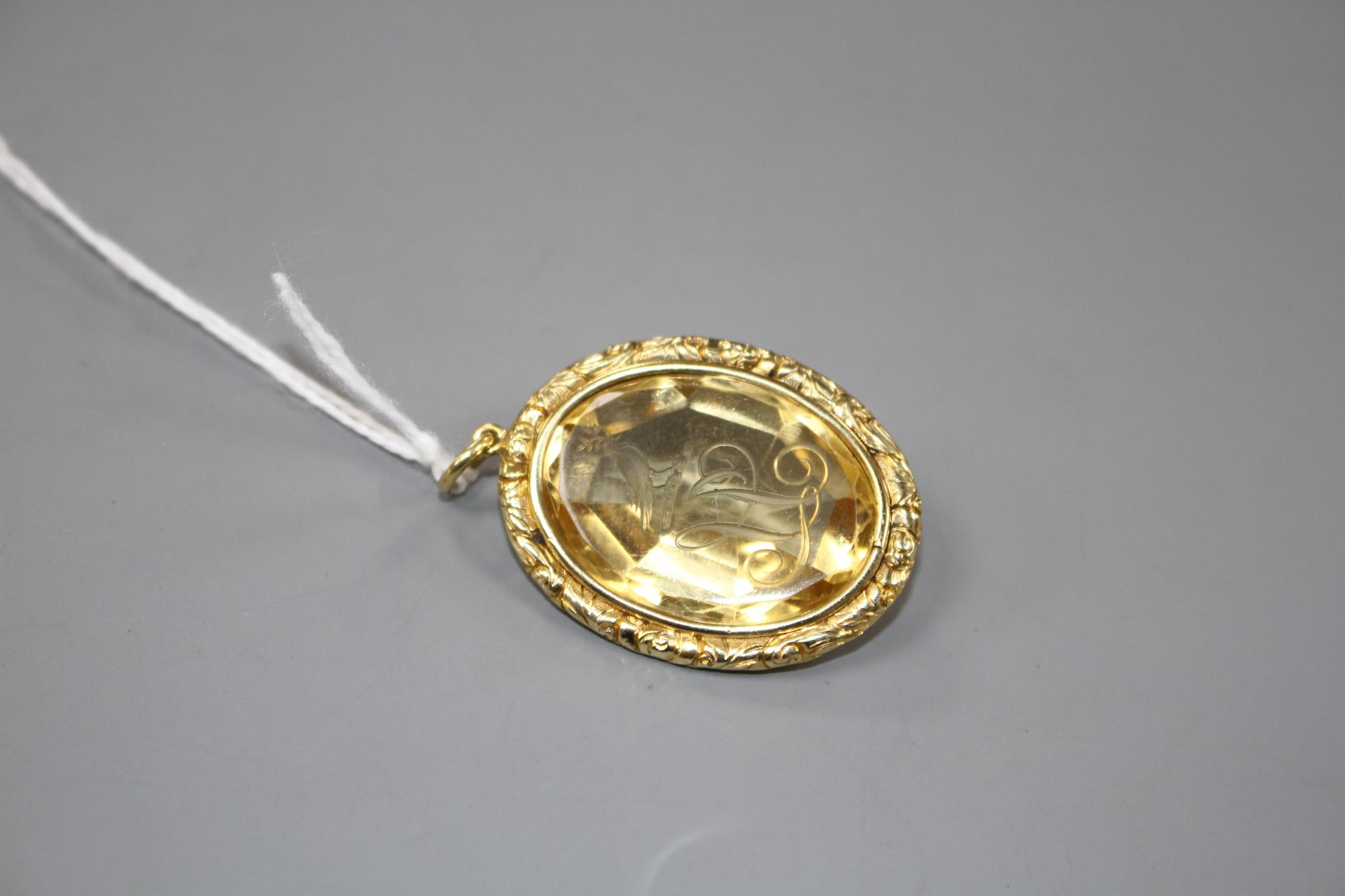 A late Victorian gilt metal mounted oval citrine pendant, engraved with a crested initial, 33mm - Image 2 of 3
