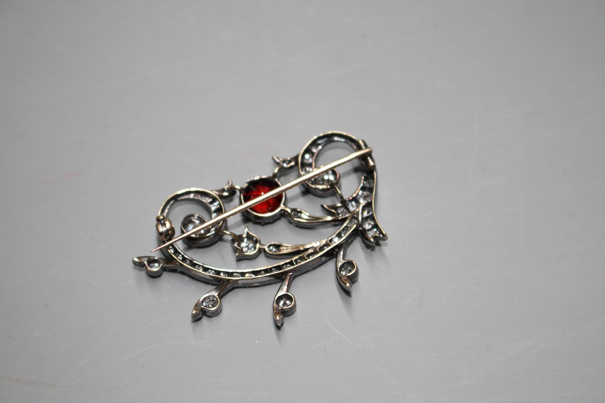 An early 20th century yellow and white metal, red spinel and diamond set foliate scroll brooch, in - Image 5 of 5