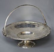 A Victorian engraved and pierced silver circular pedestal dish with swing handle, B.B, Sheffield,