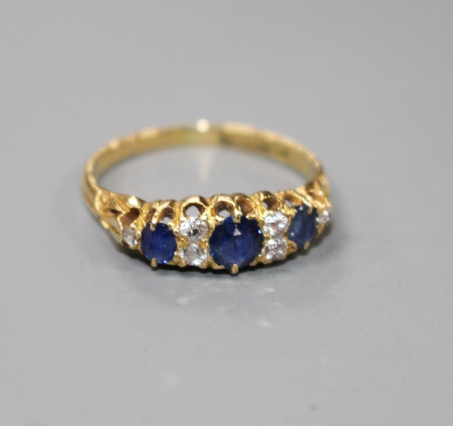 A George V 18ct gold, three stone sapphire and six stone diamond set half hoop ring, size M, gross