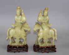 A pair of Chinese bowenite jade groups of a lady riding a horse, wood stands natural inclusions