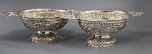 A matched pair of early 20th century Dutch repousse silver oval two handled pedestal sweetmeat