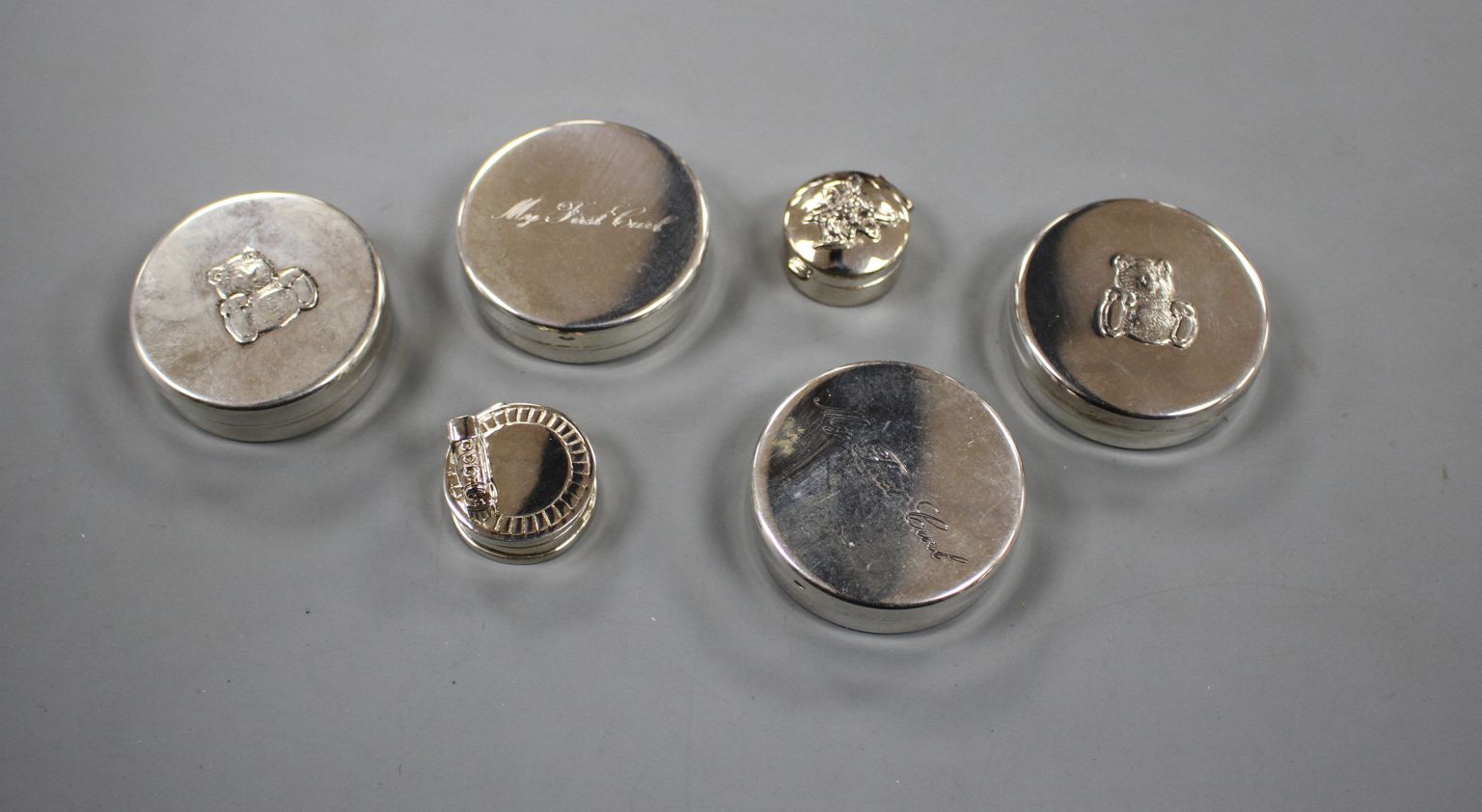 Six modern silver 'tooth fairy' circular boxes, including two 'My First Curl' boxes and one
