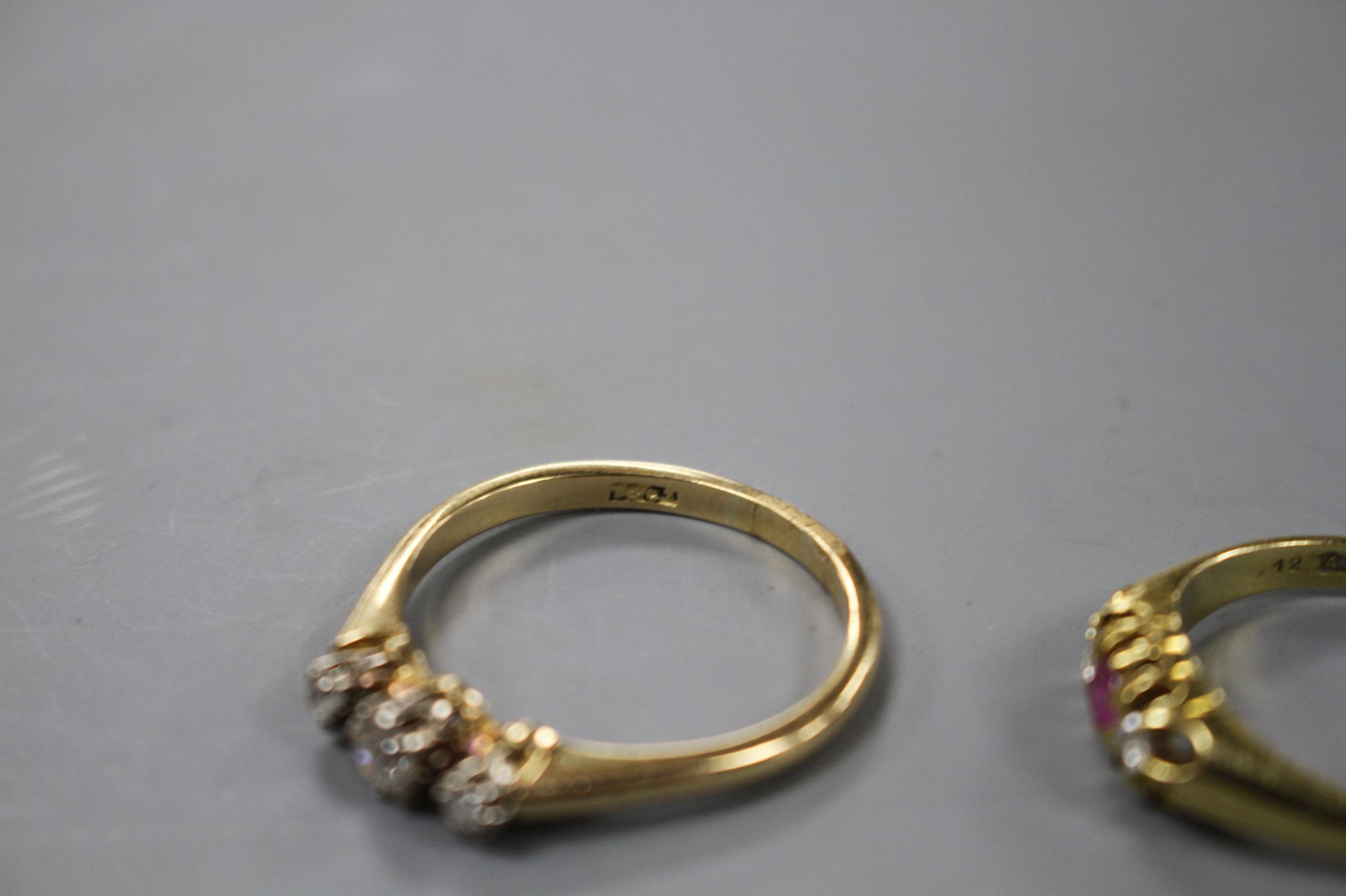 A modern 18ct gold, ruby and diamond set three stone ring and an 18ct and three stone diamond - Image 4 of 4