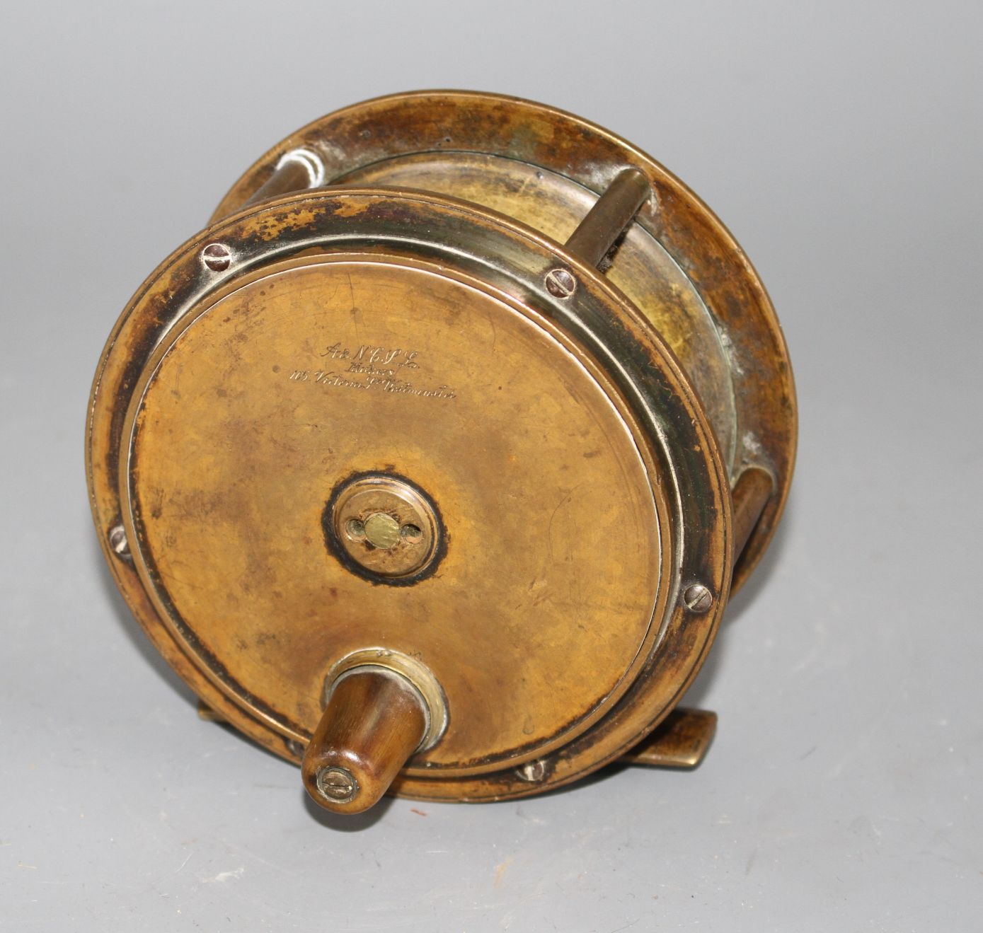 An early brass 4.5in. fishing reel by Army & Navy Cooperative Stores Ltd., engraved mark, diameter