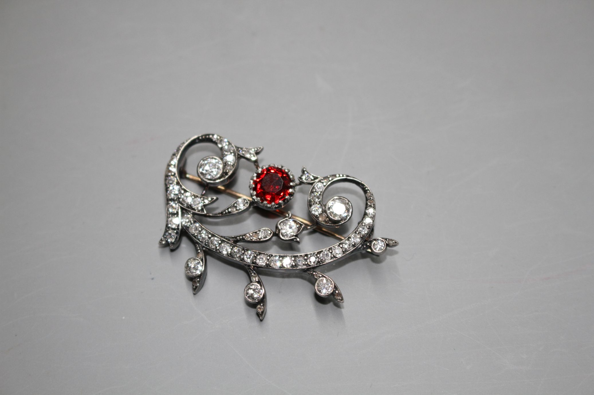 An early 20th century yellow and white metal, red spinel and diamond set foliate scroll brooch, in - Image 4 of 5