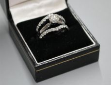 A modern 14kt white metal and triple band diamond dress ring, with two herringbone bands, each set