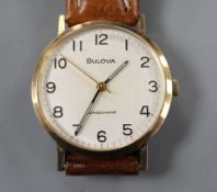 A gentleman's 9ct gold Bulova Longchamp manual wind wrist watch, on associated strap. Condition: