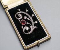 An early 20th century yellow and white metal, red spinel and diamond set foliate scroll brooch, in
