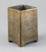 A Chinese bronze and silver inlaid square brush pot, decorated with lion dog and brocade ball