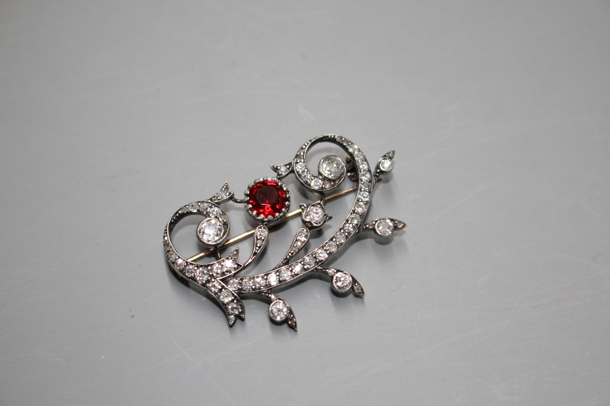 An early 20th century yellow and white metal, red spinel and diamond set foliate scroll brooch, in - Image 3 of 5