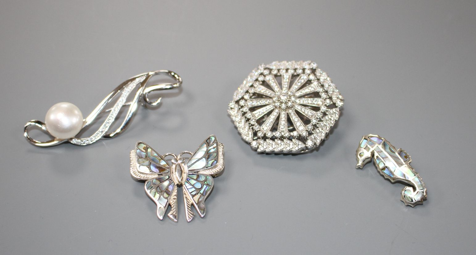 Four assorted modern 925 brooches, including paua shell butterfly and sea horse and a hexagonal