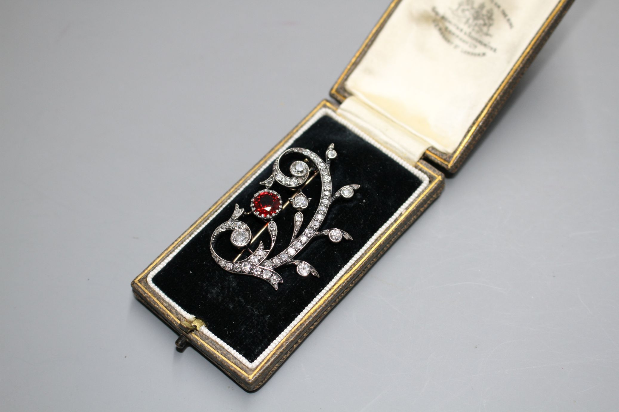 An early 20th century yellow and white metal, red spinel and diamond set foliate scroll brooch, in - Image 2 of 5