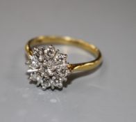 A modern 18ct and nine stone round cut diamond set flower head cluster ring, size P, gross 3.9