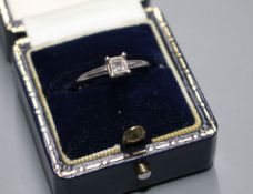 A modern 14k white metal and princess cut solitaire diamond ring, the stone weighing 0.25cts, with