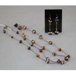 A white metal and graduated banded agate bead long necklace and pair of matching earrings,