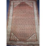 A Persian russet ground rug with central field of leaf motifs, multi-bordered, 150 x 95cm Condition: