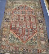 An Antique Persian red ground rug, with central medallion of boteh motifs, multi-bordered, 162 x