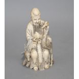 A Chinese carved ivory group of a sage holding a peach, seated beside a crane and a deer, 17cm