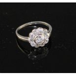 A white metal and eleven stone diamond circular cluster ring, size K, gross weight 3.1 grams.