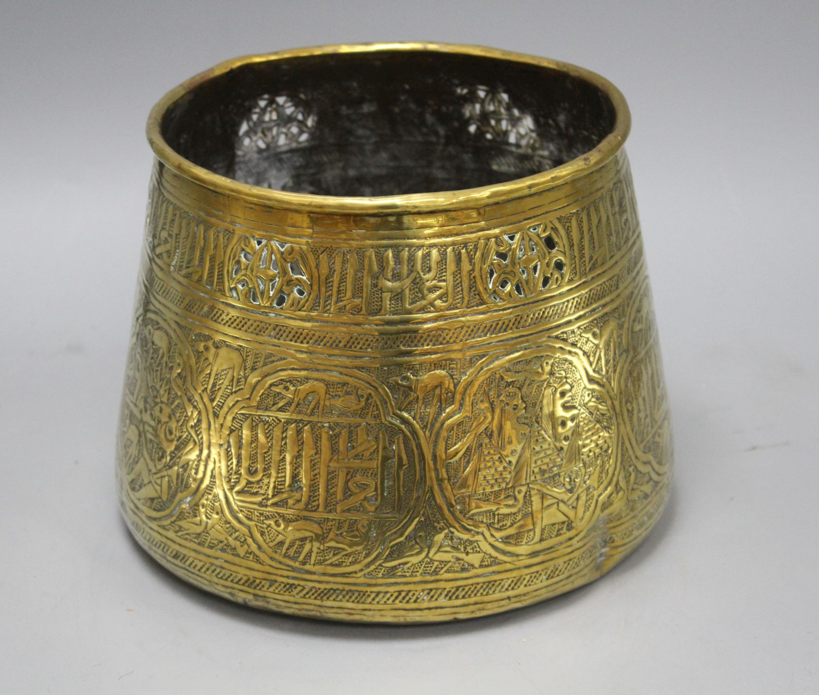 A Cairoware brass jardiniere, decorated with panels of figures and calligraphy, height 18cm,