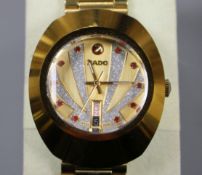 A gentleman's gilt steel Rado Diastar day/date automatic wrist watch, with red stone set markers and