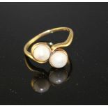 A 20th century 18ct and two stone cultured pearl set crossover ring, size O, gross weight 3.3 grams.