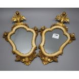 A pair of Italian giltwood cartouche shaped wall mirrors, width 25cm, height 43cm Condition: Some