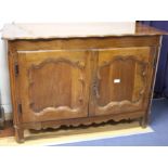 An 18th century French provincial walnut cabinet, with serpentine top and two panelled doors, W.