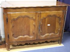 An 18th century French provincial walnut cabinet, with serpentine top and two panelled doors, W.