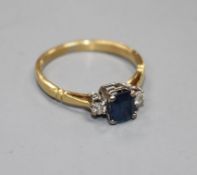 An 18ct, sapphire and diamond three stone ring, size N, gross weight 2.6 grams. Condition: A few