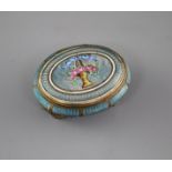 A late 19th century gilt metal and enamel oval box, decorated with a basket of flowers, with