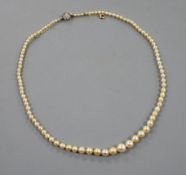 A single strand graduated natural saltwater pearl necklace, with old cut diamond cluster set