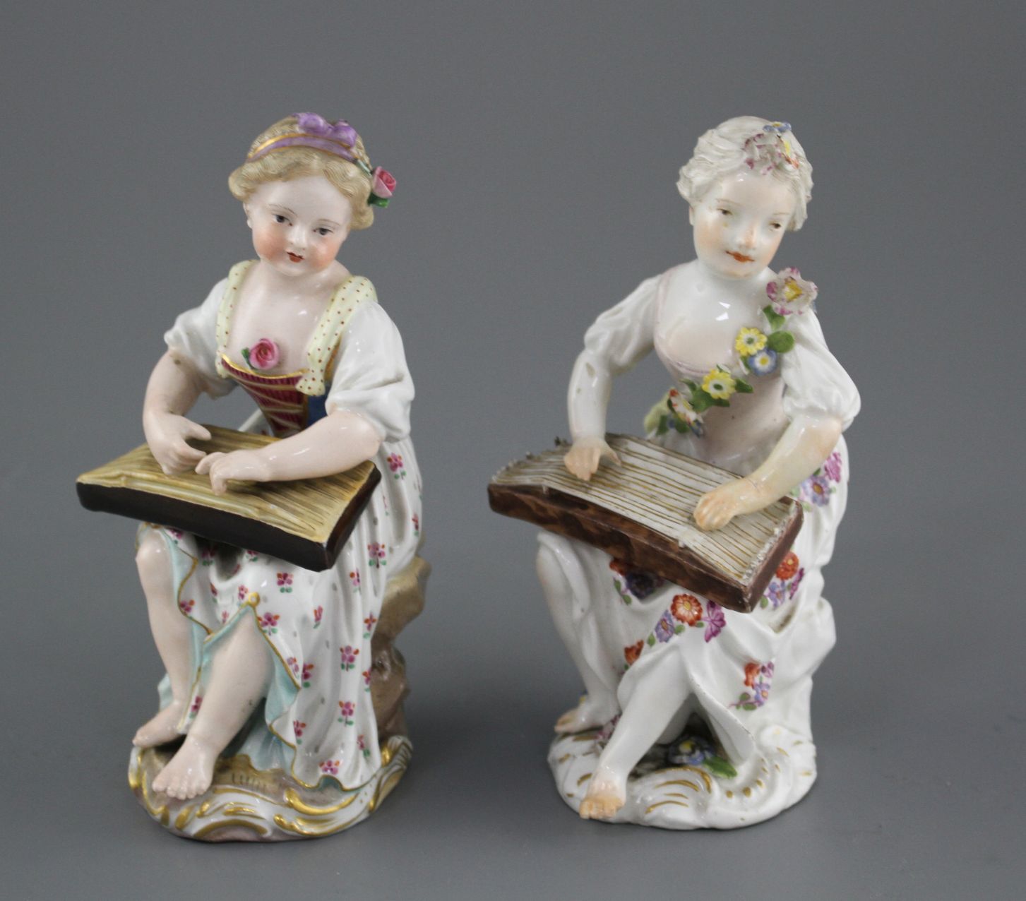 An 18th century Meissen figure of a girl playing a zither and a 19th century Meissen figure of a