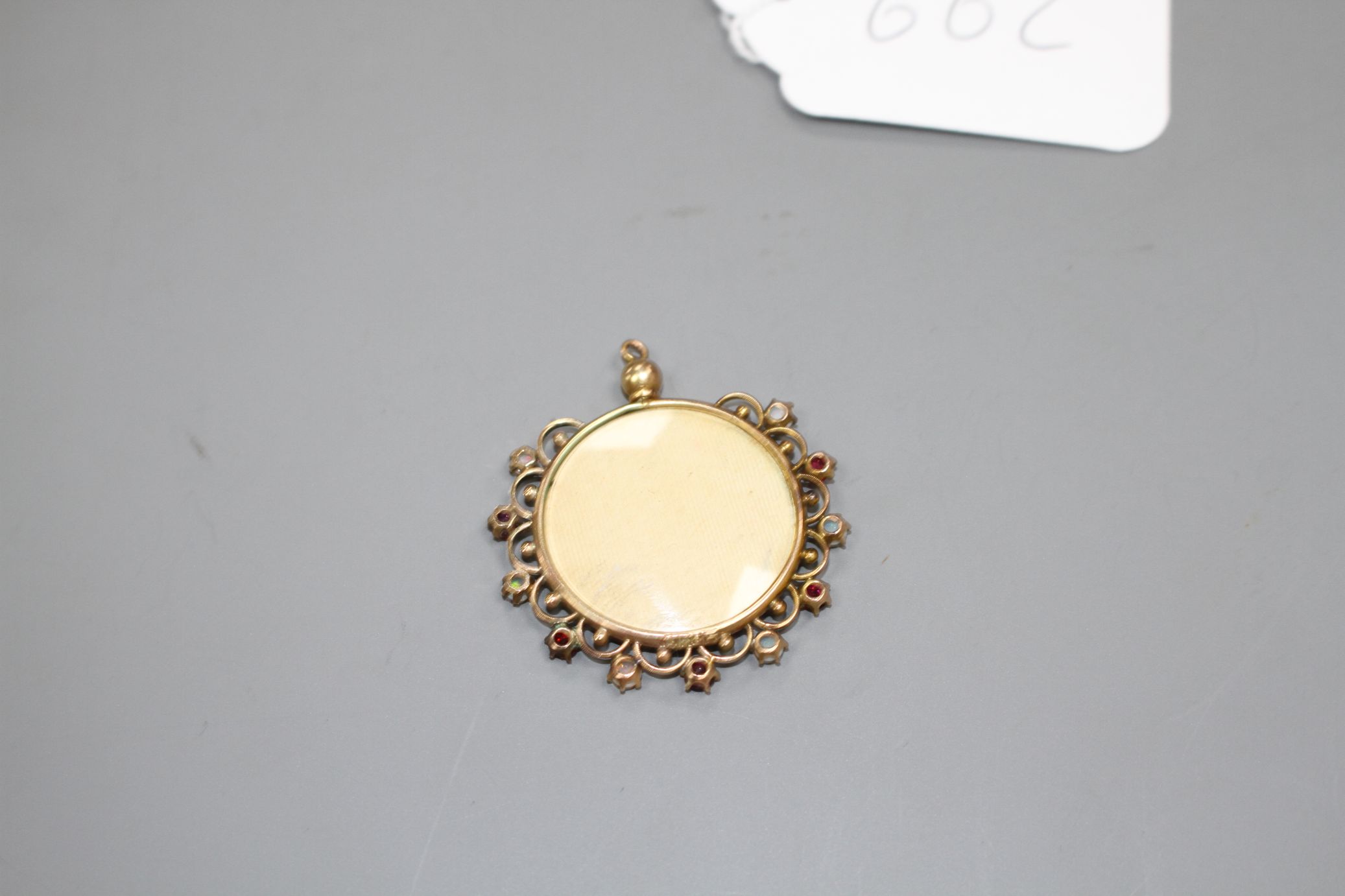 A Middle Eastern? yellow metal, white opal an red paste? set glazed circular pendant, overall - Image 2 of 2