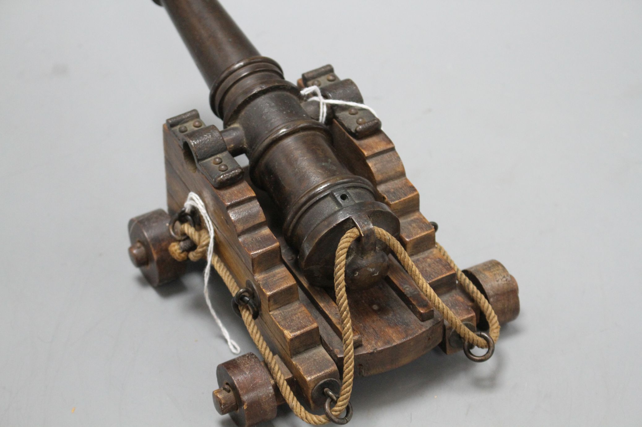 An early 20th century bronze model of a Naval cannon, on wooden trunnion base, length 25cm - Image 4 of 6
