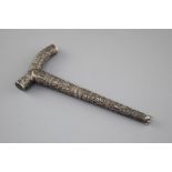 An Indian? embossed white metal cane handle, unmarked, 21.5cm, 2.5oz. Condition: Large dent to
