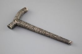 An Indian? embossed white metal cane handle, unmarked, 21.5cm, 2.5oz. Condition: Large dent to