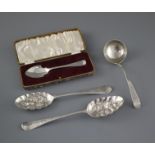 Two 18th century silver 'berry spoons' a George III silver sauce ladle, London, 1773 and a cased