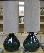 A pair of green glass lamp bases with cylindrical fabric shades, height overall 94cm, diameter