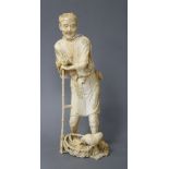 A Japanese ivory Tokyo School ivory okimono, carved as a farmer above a chicken, Meiji period,