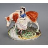 A Staffordshire pottery group of a milkmaid and cow, L. 21cm Condition: Loss to cow's right horn and