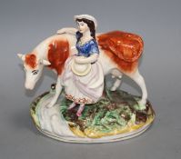 A Staffordshire pottery group of a milkmaid and cow, L. 21cm Condition: Loss to cow's right horn and