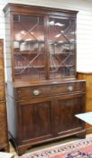 A George III style mahogany bookcase, with two astragal glazed doors over a fall front drawer and