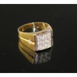 An 18k yellow metal and nine stone pave set diamond square signet ring, size W/X, gross 14.5