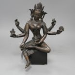 A Sino-Tibetan bronze figure of a seated female deity, on associated marble plinth, height 35cm