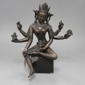 A Sino-Tibetan bronze figure of a seated female deity, on associated marble plinth, height 35cm