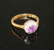 A modern 18ct gold, amethyst and diamond set circular cluster ring, size I, gross weight 3.2